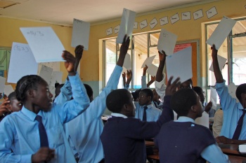 pupils holding up mini-whiteboards in a classroom